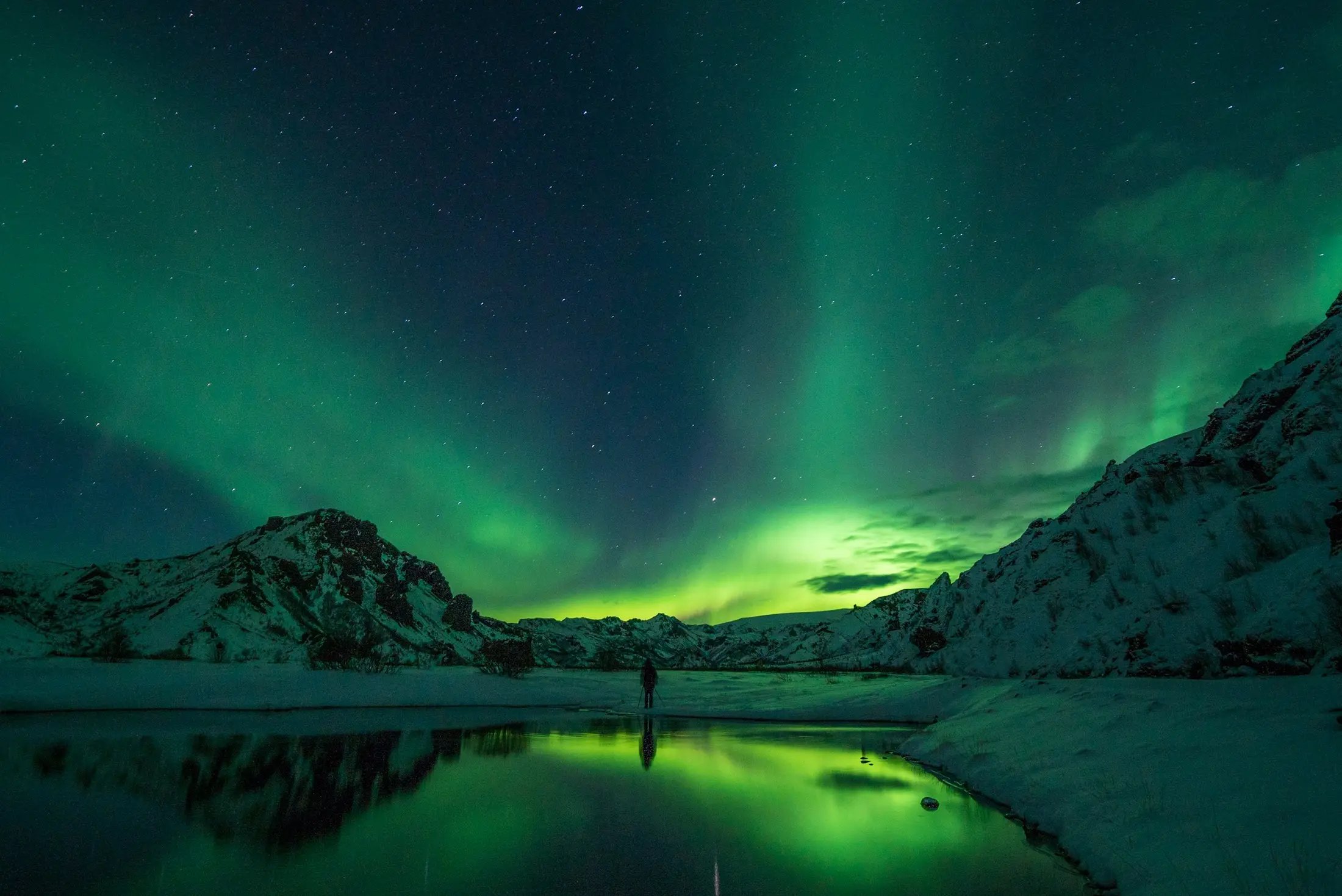 Green northern lights over Icelandic mountains at night