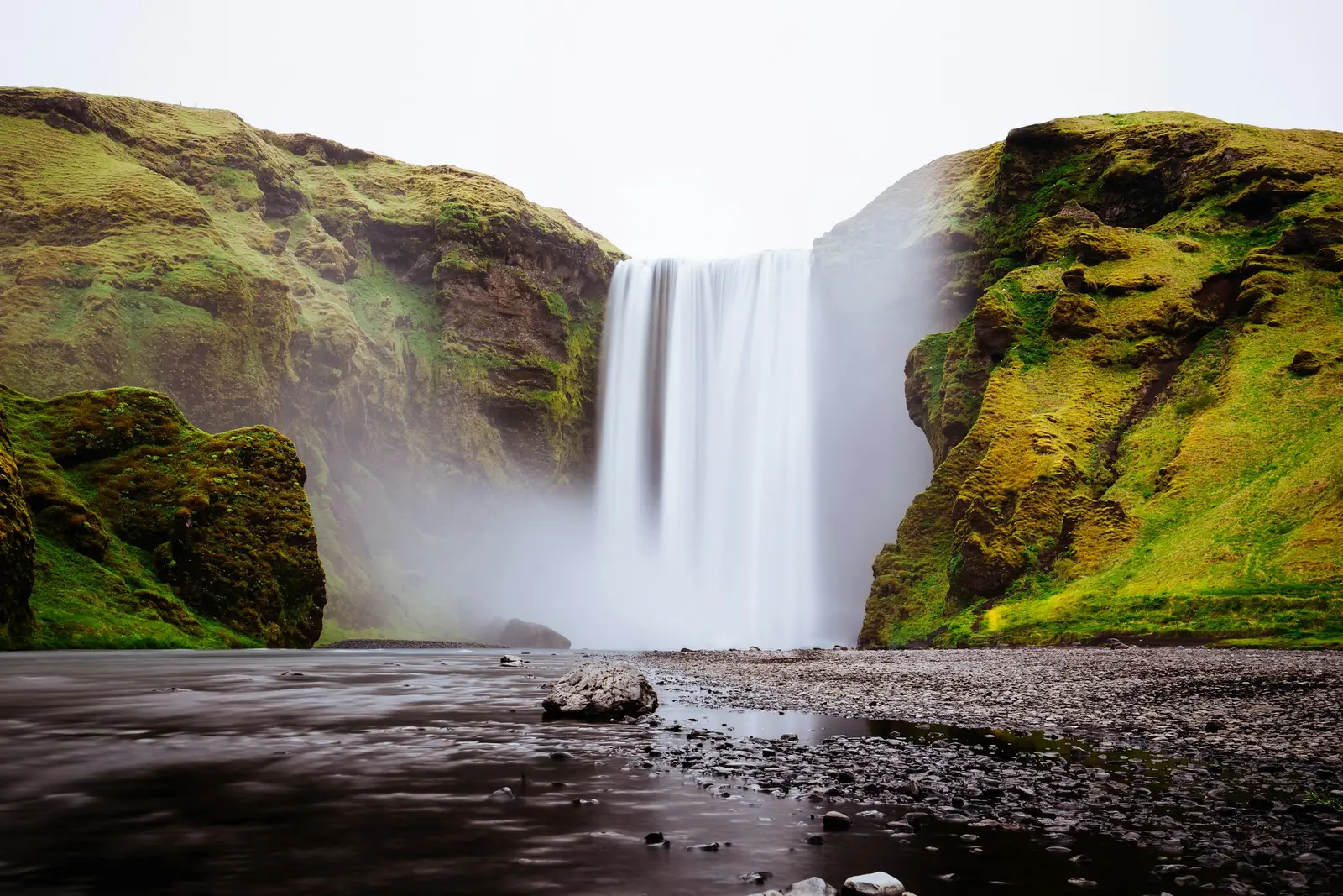 Icelandic waterfall thundering between green cliffs