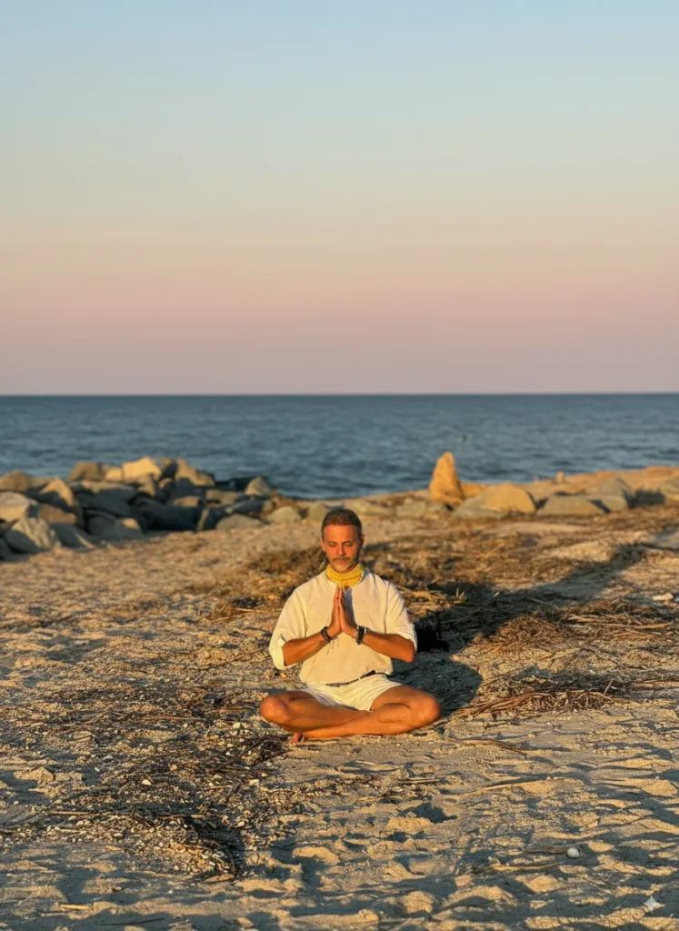 Alejandro Pérez Bolaños meditando en la playa, transmitiendo paz y conexión espiritual