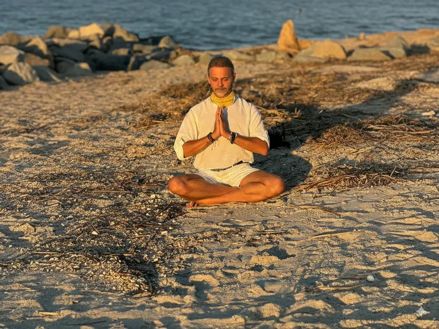 Alejandro Pérez Bolaños meditando en la playa, transmitiendo paz y conexión espiritual